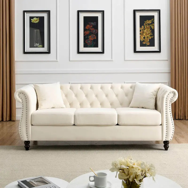 Canapé 3 places Chesterfield en velours beige, accoudoirs arrondis, garniture cloutée, structure en bois