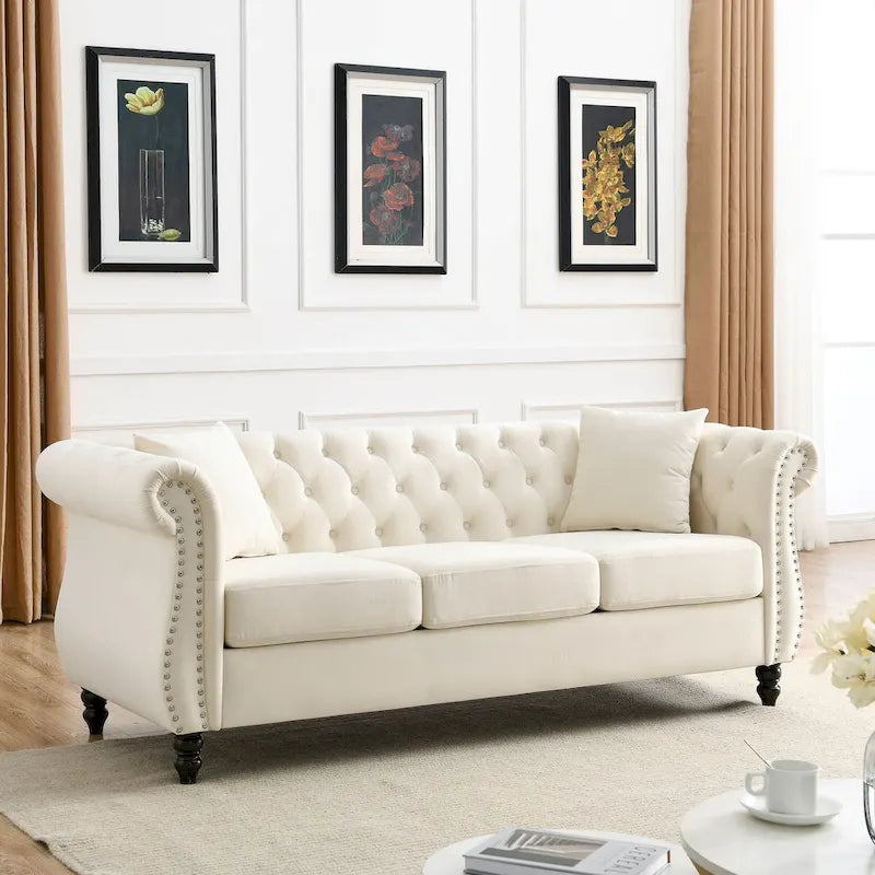 Canapé 3 places Chesterfield en velours beige, accoudoirs arrondis, garniture cloutée, structure en bois