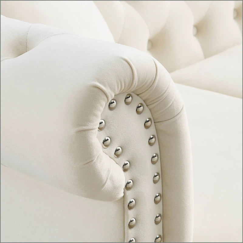 Canapé 3 places Chesterfield en velours beige, accoudoirs arrondis, garniture cloutée, structure en bois