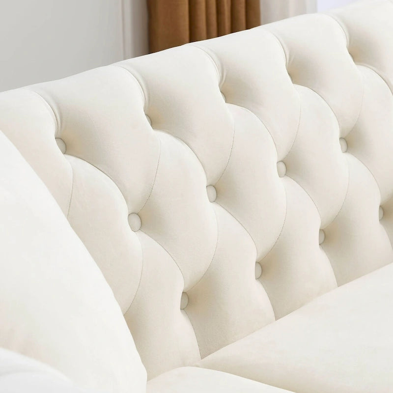 Canapé 3 places Chesterfield en velours beige, accoudoirs arrondis, garniture cloutée, structure en bois