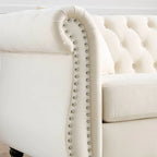 Canapé 3 places Chesterfield en velours beige, accoudoirs arrondis, garniture cloutée, structure en bois