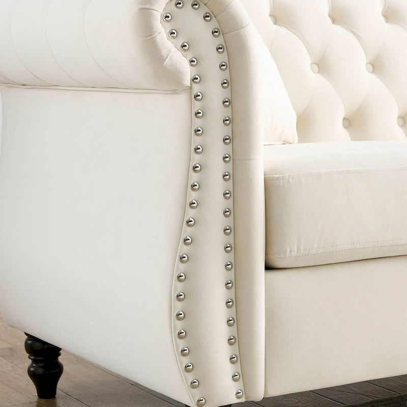 Canapé 3 places Chesterfield en velours beige, accoudoirs arrondis, garniture cloutée, structure en bois