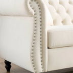 Canapé 3 places Chesterfield en velours beige, accoudoirs arrondis, garniture cloutée, structure en bois