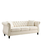 Canapé 3 places Chesterfield en velours beige, accoudoirs arrondis, garniture cloutée, structure en bois