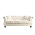 Canapé 3 places Chesterfield en velours beige, accoudoirs arrondis, garniture cloutée, structure en bois